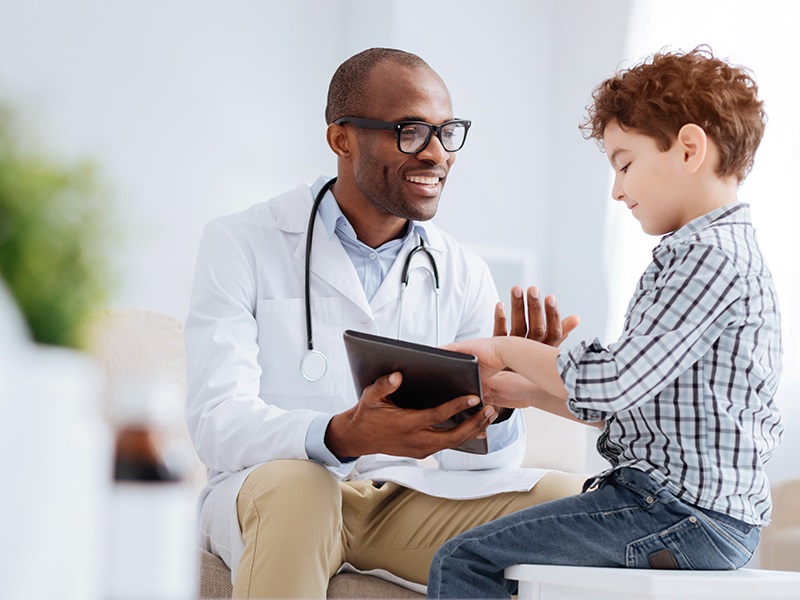 A smiling doctor treating a young boy - mobile photo