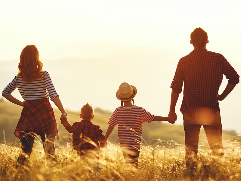 Family standing in a meadow - mobile